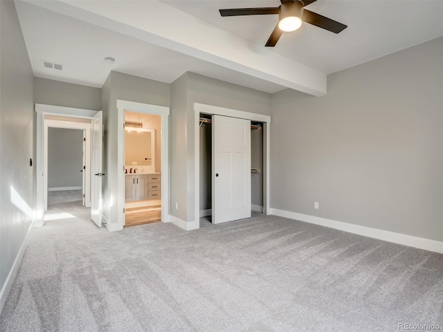 unfurnished bedroom with a closet, ceiling fan, ensuite bathroom, and light carpet