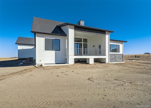 rear view of property featuring central AC unit and a porch