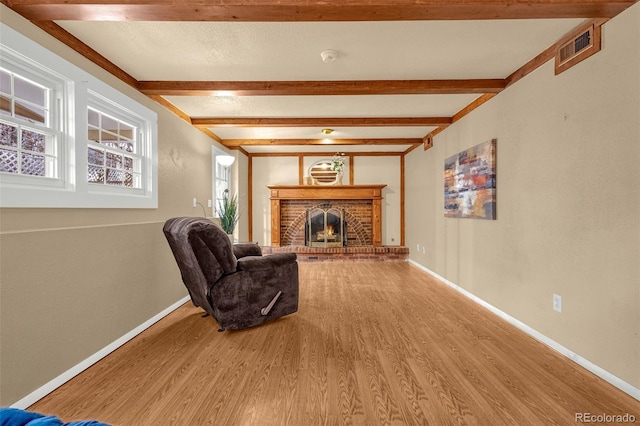 2706 Penacho Cir, Colorado Springs, CO 80917 - living room featuring wood finished floors, beam ceiling, a fireplace, and baseboards