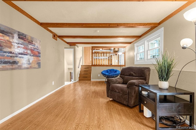2706 Penacho Cir, Colorado Springs, CO 80917 - sitting room featuring light wood-type flooring, beamed ceiling, stairway, and baseboards