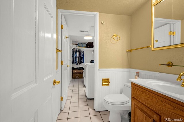 2706 Penacho Cir, Colorado Springs, CO 80917 - bathroom with tile patterned flooring, washer / clothes dryer, a wainscoted wall, toilet, and vanity