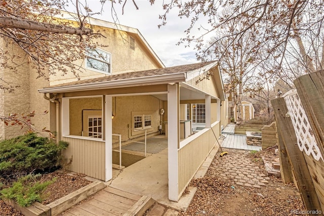 2706 Penacho Cir, Colorado Springs, CO 80917 - view of side of home with stucco siding, a wooden deck, a patio, and roof with shingles