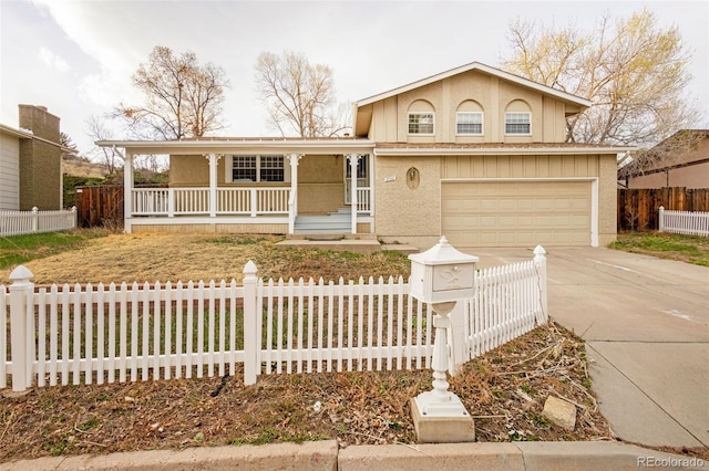 2706 Penacho Cir, Colorado Springs, CO 80917 - view of front of home featuring covered porch, concrete driveway, an attached garage, and a fenced front yard
