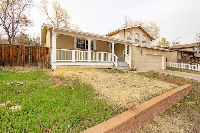 2706 Penacho Cir, Colorado Springs, CO 80917 - view of front of house with covered porch, fence, driveway, a garage, and stucco siding