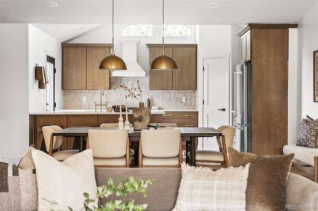 13416 W 22nd Pl, Golden, CO 80401 - kitchen featuring decorative light fixtures, high quality fridge, custom range hood, and tasteful backsplash