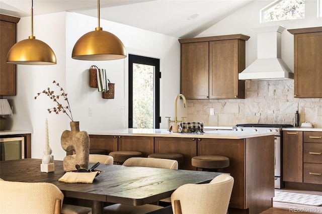13416 W 22nd Pl, Golden, CO 80401 - kitchen featuring wall chimney range hood, tasteful backsplash, stainless steel gas stove, and lofted ceiling
