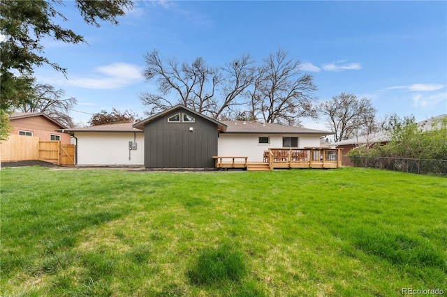 13416 W 22nd Pl, Golden, CO 80401 - back of property featuring a fenced backyard, a wooden deck, and a lawn