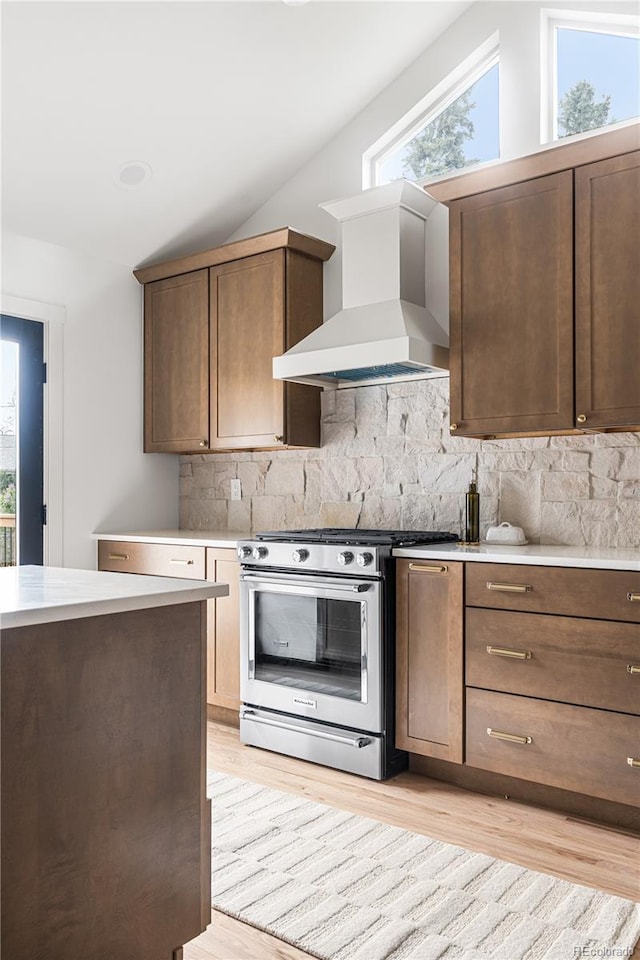 13416 W 22nd Pl, Golden, CO 80401 - kitchen with a healthy amount of sunlight, stainless steel range with gas stovetop, wall chimney exhaust hood, and lofted ceiling