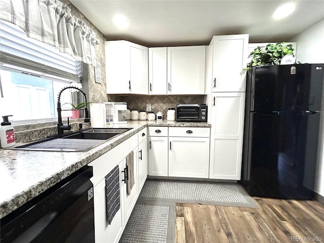 kitchen featuring black appliances, a sink, and white cabinetry