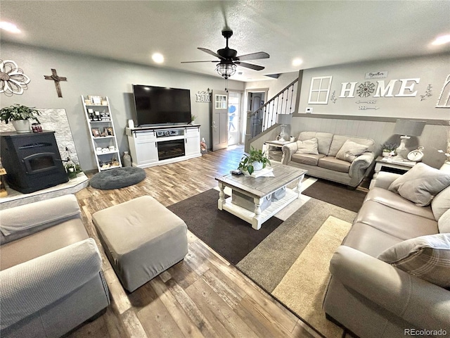 living area with ceiling fan, wood finished floors, stairs, recessed lighting, and a textured ceiling