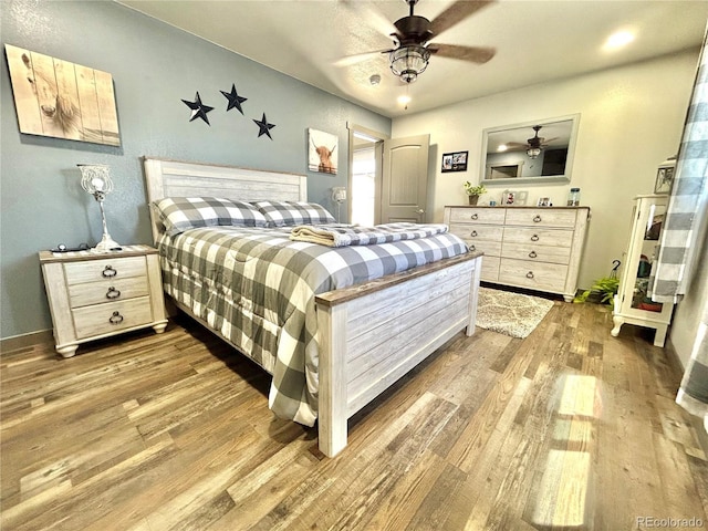 bedroom with wood finished floors, baseboards, and ceiling fan