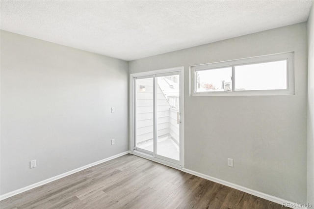 17094 E Tennessee Dr Unit 212, Aurora, CO 80017 - empty room featuring wood finished floors, baseboards, and a textured ceiling