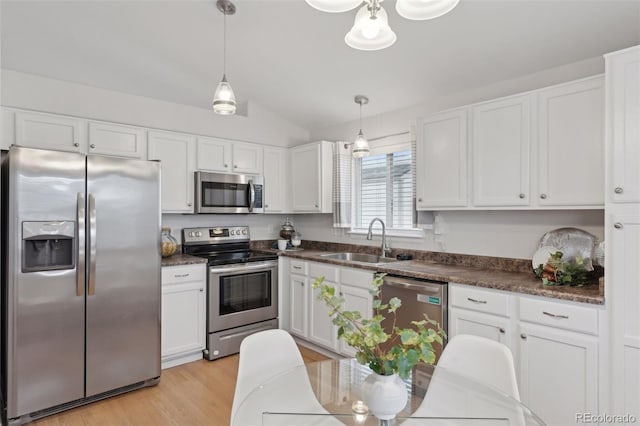 kitchen featuring decorative light fixtures, appliances with stainless steel finishes, sink, and white cabinetry