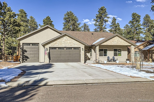 ranch-style home with roof with shingles, stucco siding, concrete driveway, an attached garage, and stone siding