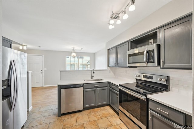 kitchen with appliances with stainless steel finishes, a sink, a peninsula, decorative backsplash, and open shelves