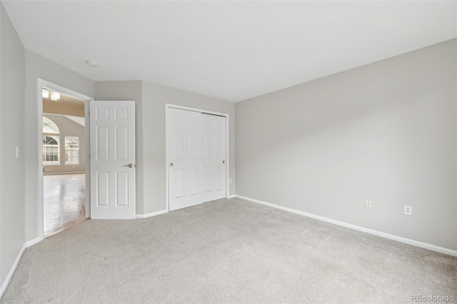 unfurnished bedroom with carpet floors, baseboards, and a closet