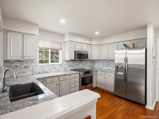 kitchen featuring a sink, white cabinetry, decorative backsplash, and stainless steel appliances