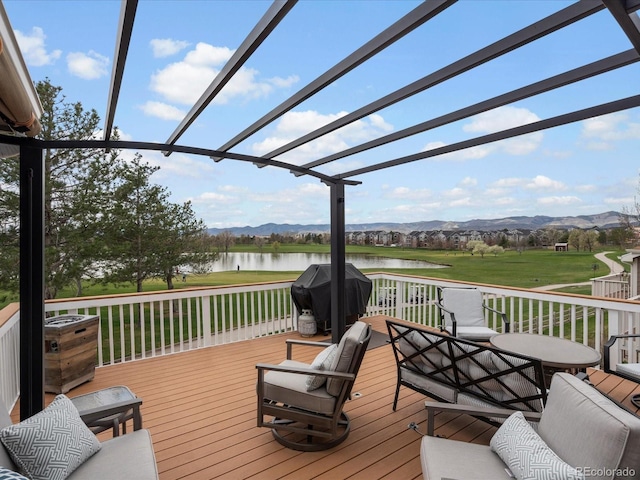 wooden terrace with a pergola, grilling area, a water and mountain view, a lawn, and view of golf course