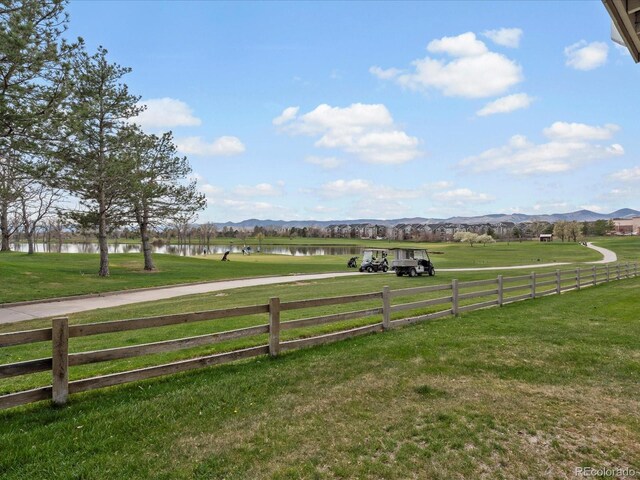 view of yard featuring fence and a water and mountain view