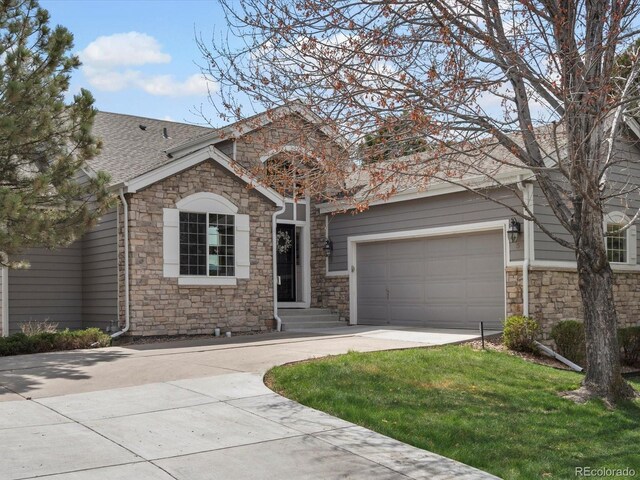 ranch-style home with concrete driveway, roof with shingles, an attached garage, and stone siding
