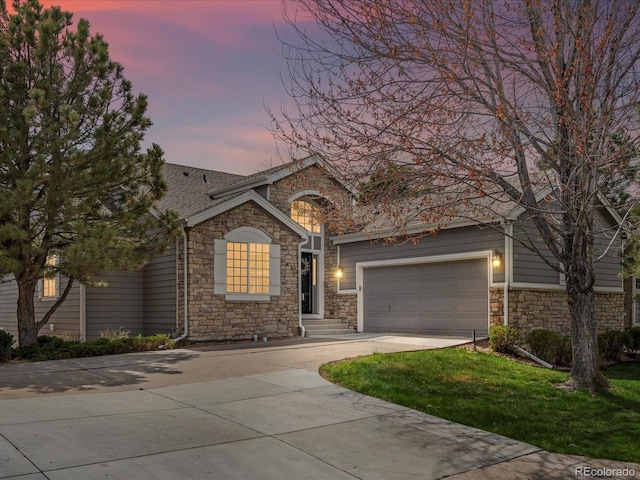 single story home with an attached garage, a front lawn, stone siding, and concrete driveway