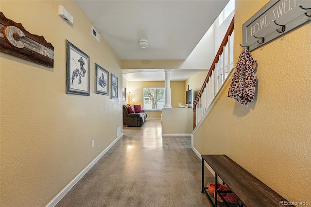 4705 Andes St, Denver, CO 80249 - hallway with ornate columns, finished concrete flooring, stairs, baseboards, and a textured wall