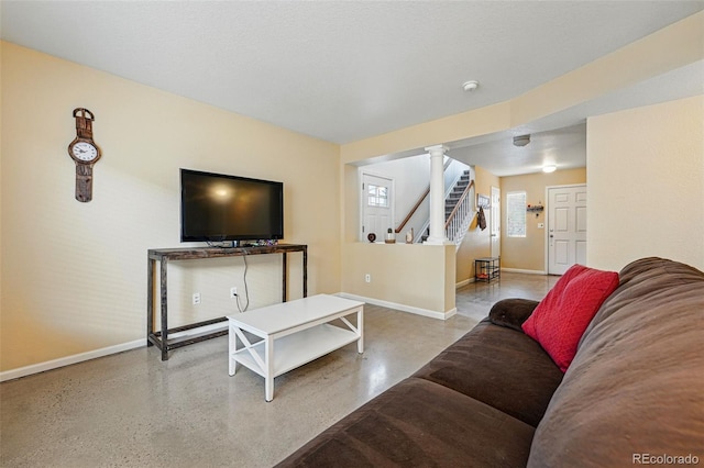 4705 Andes St, Denver, CO 80249 - living area with baseboards, stairway, and decorative columns