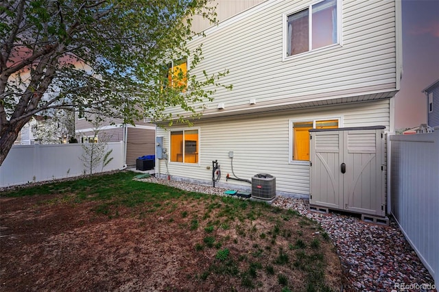 4705 Andes St, Denver, CO 80249 - back of house featuring central air condition unit, a fenced backyard, a storage shed, and an outdoor structure