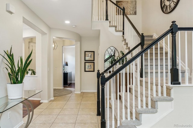 tiled entrance foyer featuring stairway, baseboards, and recessed lighting