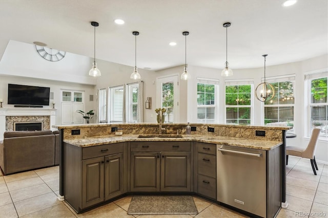 kitchen with stainless steel dishwasher, a sink, open floor plan, light tile patterned floors, and light stone counters