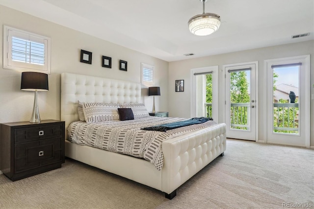 bedroom with access to exterior and light carpet