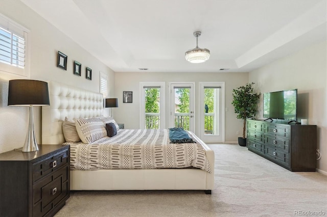bedroom with carpet, a tray ceiling, and baseboards