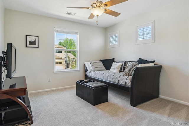 living area featuring a ceiling fan, carpet flooring, and baseboards