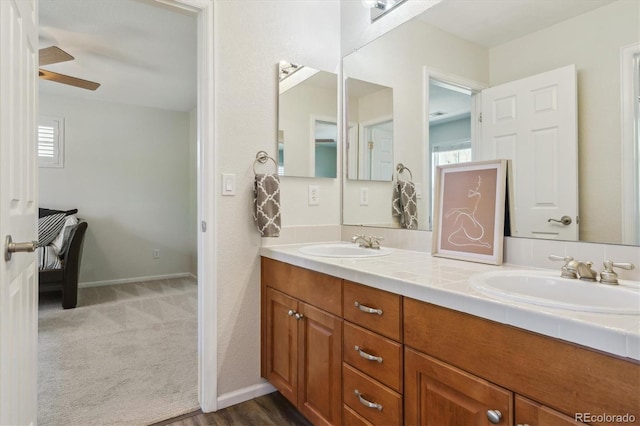 full bath featuring double vanity, healthy amount of natural light, and a ceiling fan