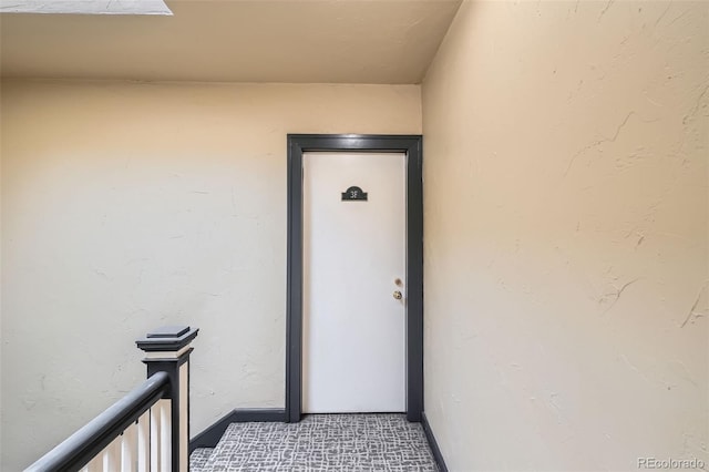property entrance featuring stucco siding and a balcony