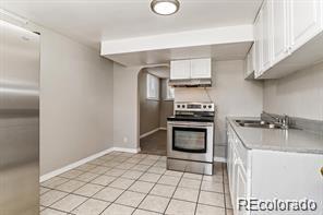 kitchen with sink, appliances with stainless steel finishes, white cabinetry, and light tile patterned floors