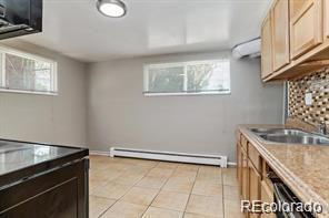 2275 S Cherokee St, Denver, CO 80223 - kitchen featuring a baseboard heating unit, light tile patterned flooring, light countertops, and a sink