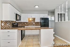 2275 S Cherokee St, Denver, CO 80223 - kitchen with black appliances, light tile patterned flooring, decorative backsplash, white cabinetry, and baseboards