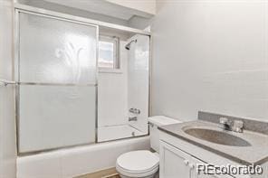 full bathroom with vanity, enclosed tub / shower combo, and toilet