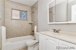 full bathroom with vanity, tiled shower / bath combo, and toilet