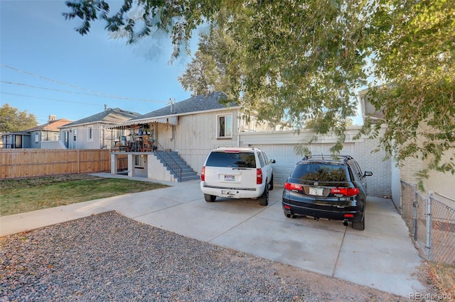 2275 S Cherokee St, Denver, CO 80223 - view of front of property with concrete driveway, a garage, and stairs
