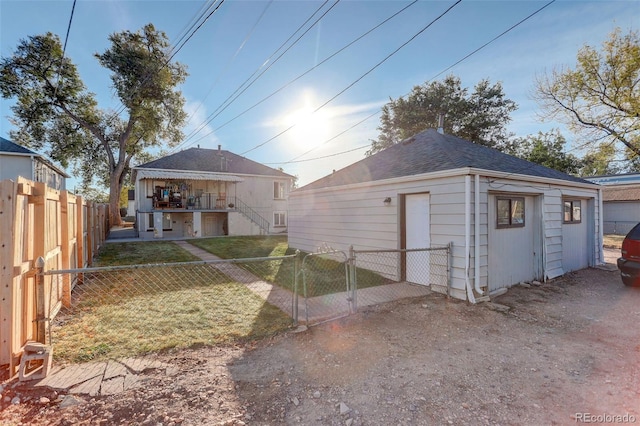 2275 S Cherokee St, Denver, CO 80223 - back of property featuring a gate, stairway, and roof with shingles