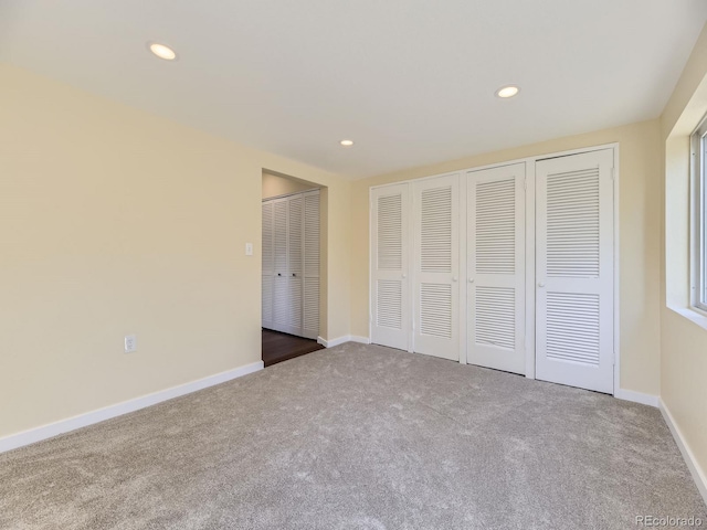 unfurnished bedroom with carpet and multiple closets