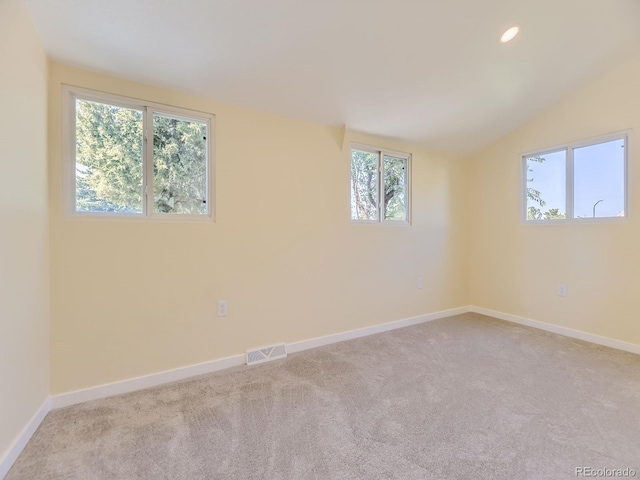 carpeted spare room with lofted ceiling