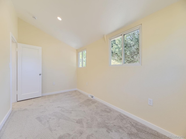 carpeted empty room with lofted ceiling