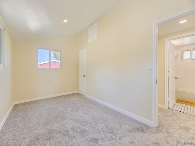 carpeted spare room featuring lofted ceiling