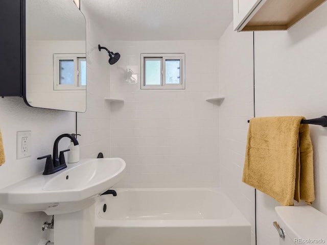 bathroom featuring tiled shower / bath combo and toilet