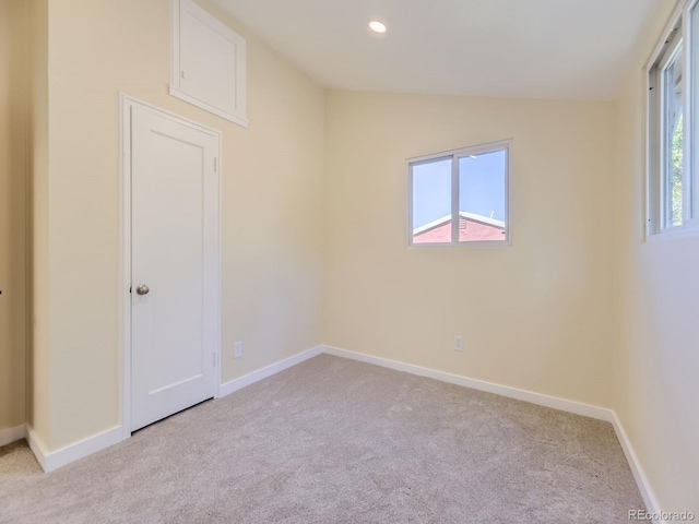 carpeted empty room featuring vaulted ceiling