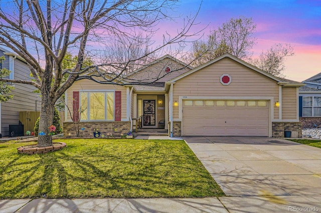 2556 E 131st Pl, Thornton, CO 80241 - view of front of home with concrete driveway, an attached garage, a yard, and stone siding