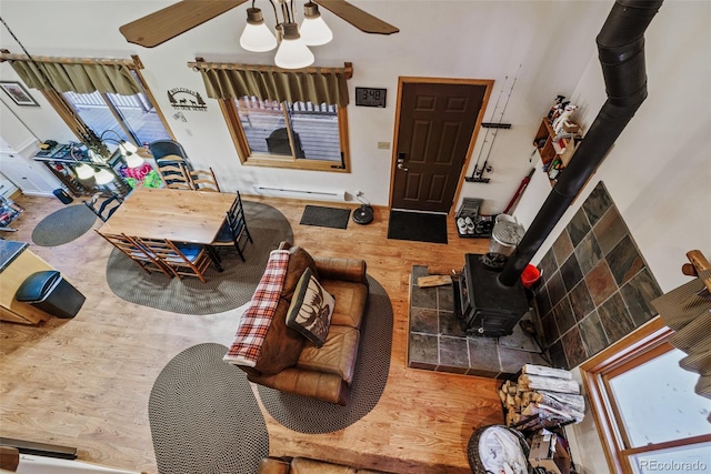2150 Michigan Hill Rd, Jefferson, CO 80456 - living area featuring a wood stove, wood finished floors, a ceiling fan, and baseboard heating